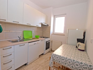 Enjoy cooking in this well-equipped kitchen with a stove, countertop, and dining area nearby.