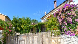 A residential area with a stone wall, a wooden fence, and houses with balconies. - Apartment 1122 (Liznjan)