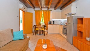 A compact living space with a kitchenette, a dining area, and a sofa. - Apartment 1122 (Liznjan)