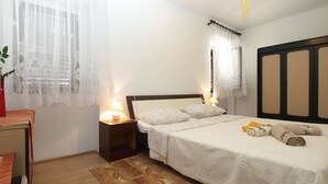 A bedroom with a bed, nightstands, a desk, and a ceiling fan. - Apartment 1123 (Vodnjan)