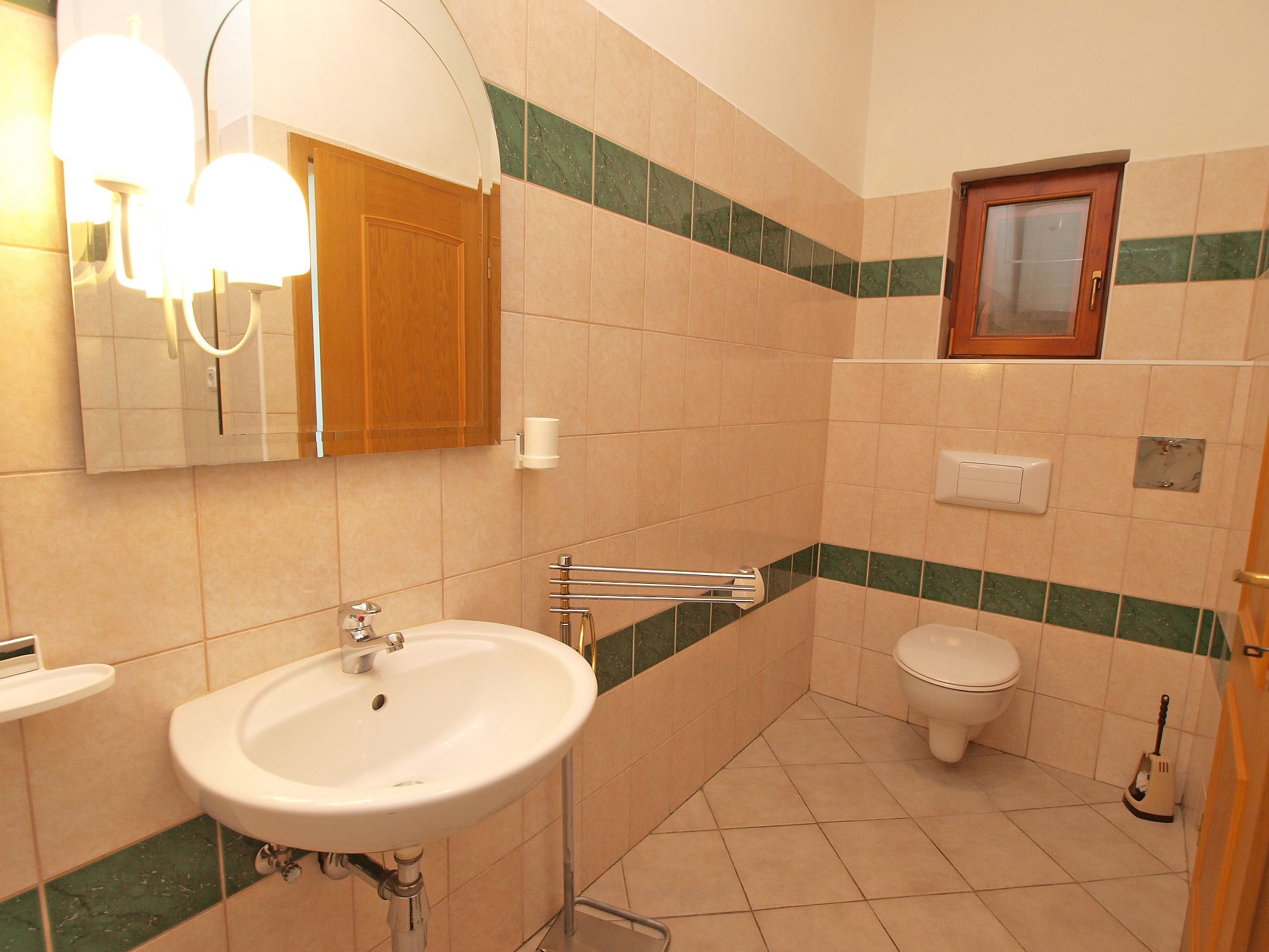 Une salle de bain avec un lavabo, des toilettes et un miroir.