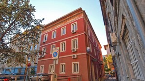 A red building with multiple windows, a no-parking sign, and a Coca-Cola sign. - Apartment 1175 (Pula)
