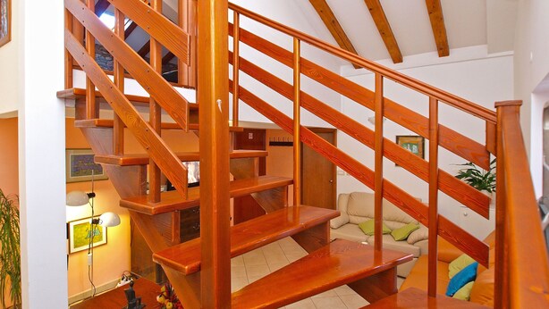 A wooden staircase with a handrail, leading to an upper floor. - Apartment 1175 (Pula)