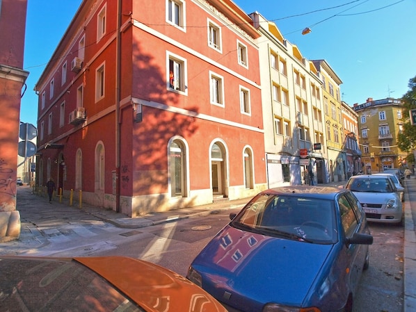 A red building with arched windows and a yellow building next to it.