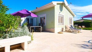 Il s’agit d’un petit bâtiment d’un seul étage doté d’un patio. On y trouve deux espaces extérieurs aménagés avec des chaises et des tables, ainsi qu’une petite table avec un banc.