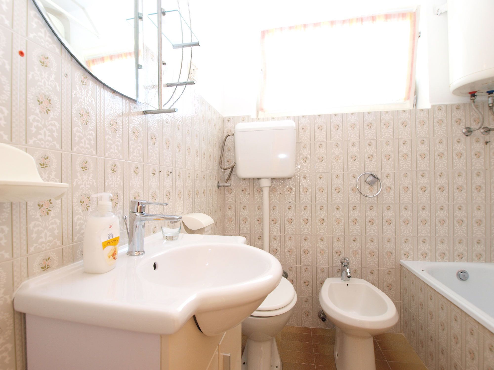 Un baño con lavamanos, inodoro, bidé y bañera.