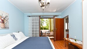 A bedroom with a bed, a desk, and a view of the outdoors. - Apartment 1230 (Pula)