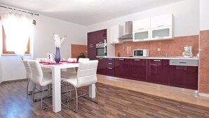 A modern kitchen with white cabinets, a microwave, and a coffee maker. - House 1277 (Visnjan)