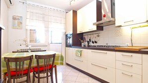 A kitchen with a dining table, chairs, and a window. - Apartment 1286 (Pula)