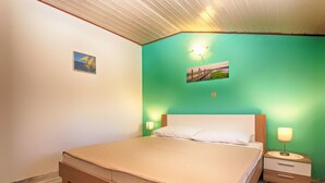 Ein Schlafzimmer mit einem hölzernen Bett, grünen Wänden und zwei Nachttischlampen.