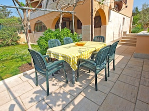 An outdoor patio with a table set for four, surrounded by green chairs, and a yellow checkered tablecloth. - Apartment 1316 (Pula)
