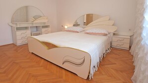 A bedroom with a bed, two bedside tables, a dresser, and a large mirror. - Apartment 1341 (Pula)