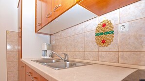 Una cocina con un lavamanos doble, armarios de madera y un adorno en la pared.