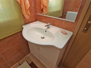A bathroom with a white sink, a mirror, and a towel rack.
