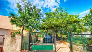 A gated entrance with a metal gate and a green bench. - Apartment 1388 (Vodnjan)