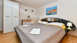 Une chambre à coucher avec un lit, une table de chevet, une commode et un tableau au mur.