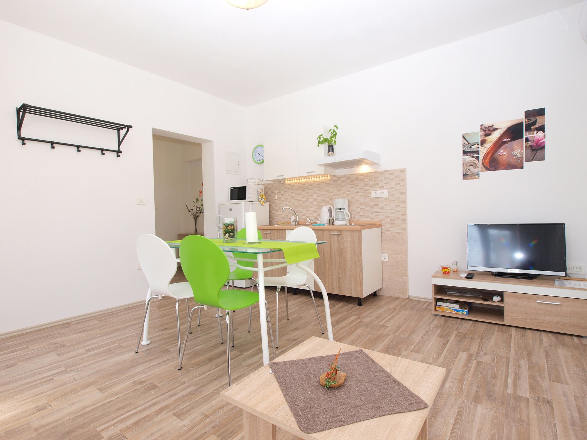A modern kitchen with a microwave, coffee maker, and a clock on the wall.
