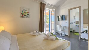 A hotel room with a bed, a TV, a bathroom, and a balcony. - Villa 1404 (Zminj)