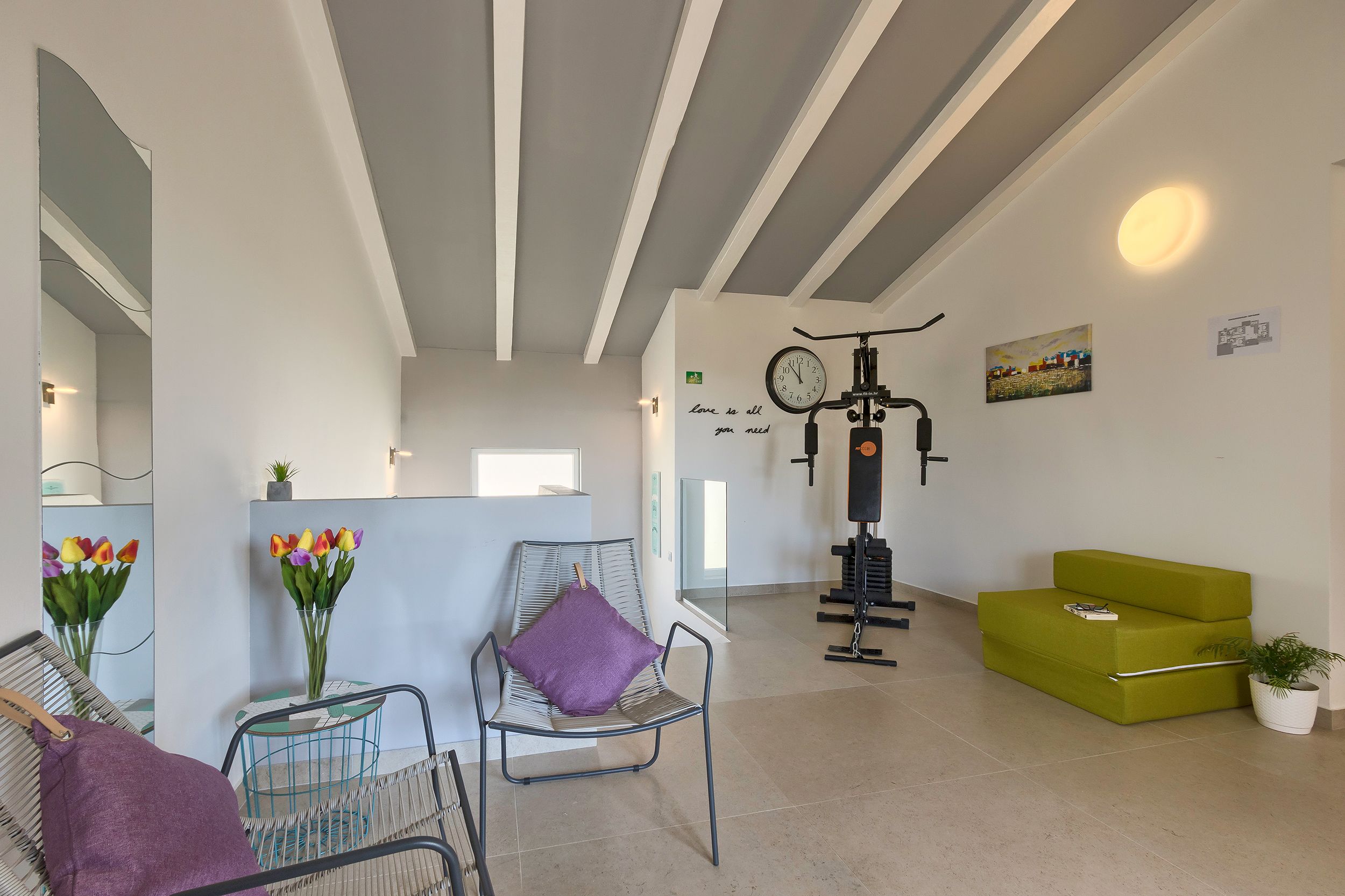 A modern reception area with a reception desk, a chair with a purple cushion, a green sofa, and a wall clock.
