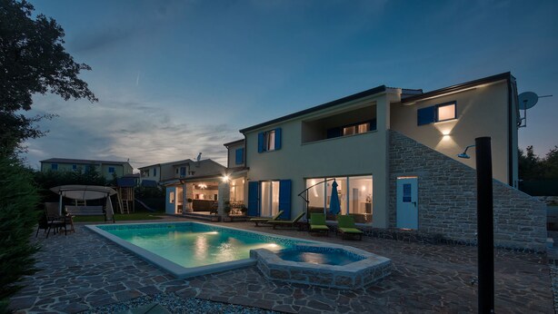 A modern house with a swimming pool, stone patio, and outdoor seating area. - Villa 1522 (Zminj)