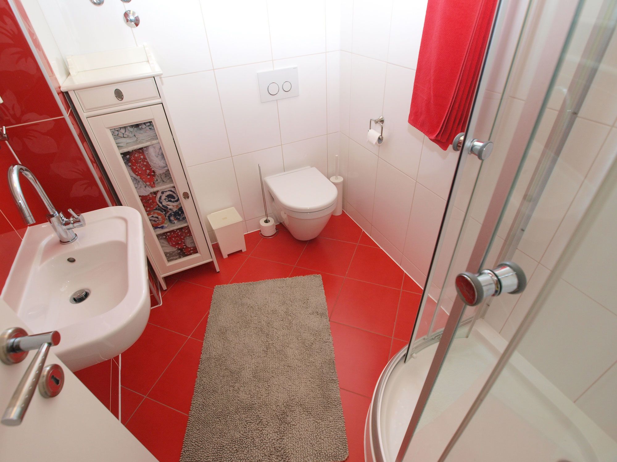 A bathroom with a sink, toilet, and shower.