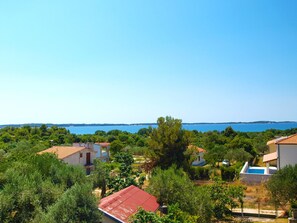 A coastal residential area with houses, a swimming pool, and a clear view of the sea. - Apartment 1418 (Vodnjan)
