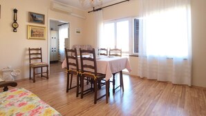 Un coin repas avec des chaises en bois, une table et un lustre.