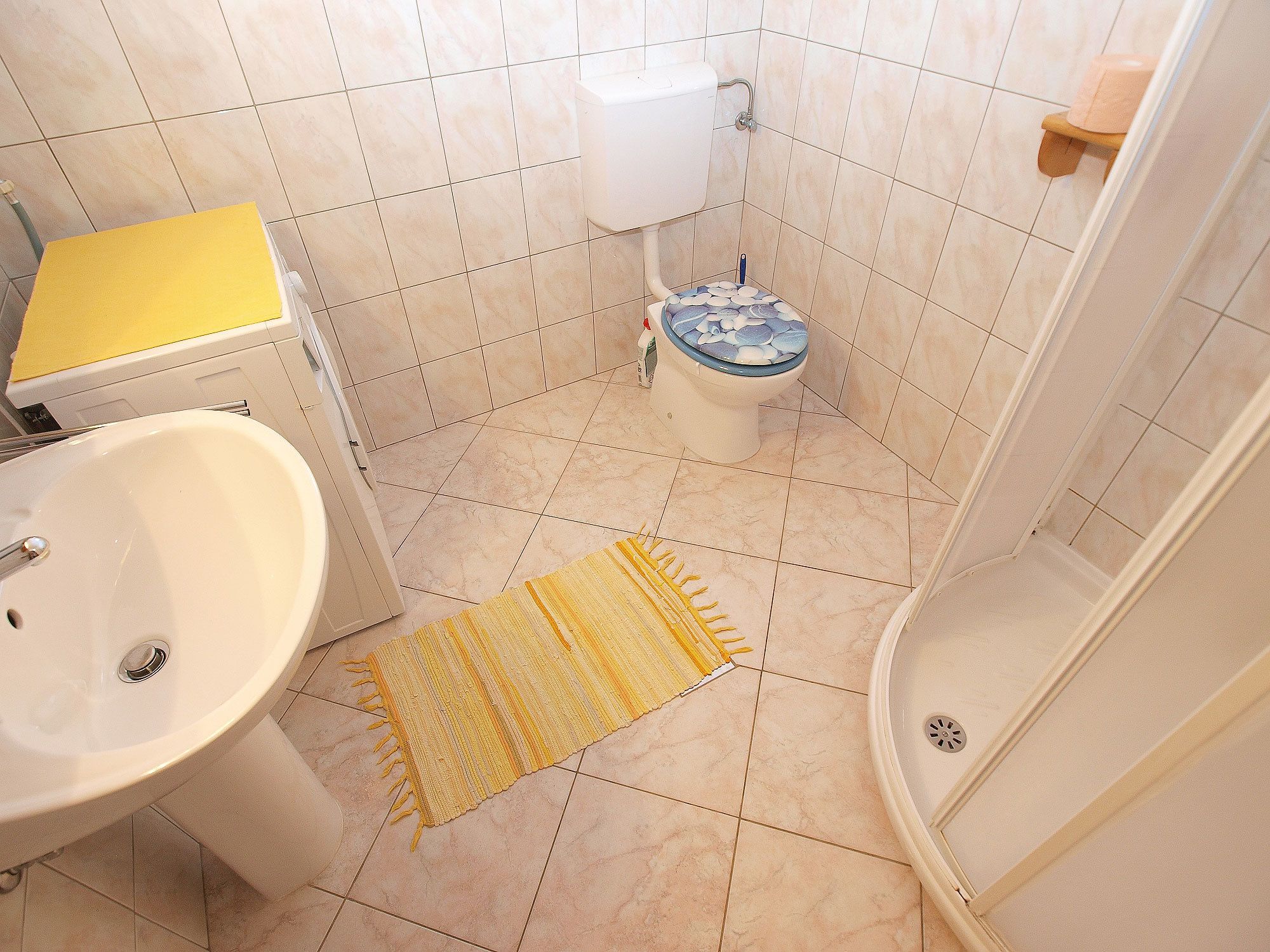 A bathroom with a sink, toilet, and shower.