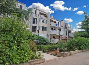 A multi-story residential building with balconies, surrounded by greenery and a clear sky. - Apartment 1475 (Fazana)