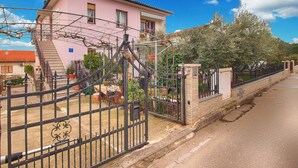 A pink villa with a gated entrance, a staircase, and a garden. - Apartment 1540 (Pula)