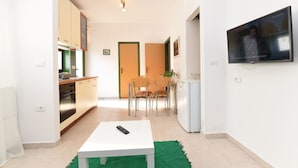 Una cocina moderna con estufa, armarios y un comedor con sillas y mesa.
