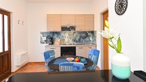 Una cocina compacta con armarios de madera, estufa integrada y salpicadero con un diseño abstracto azul y blanco.