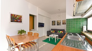 Una cocina moderna con comedor, sofá y televisor.