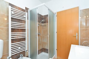 A modern bathroom with a glass-enclosed shower, a white sink, and a towel rack. - Apartment 1552 (Pula)