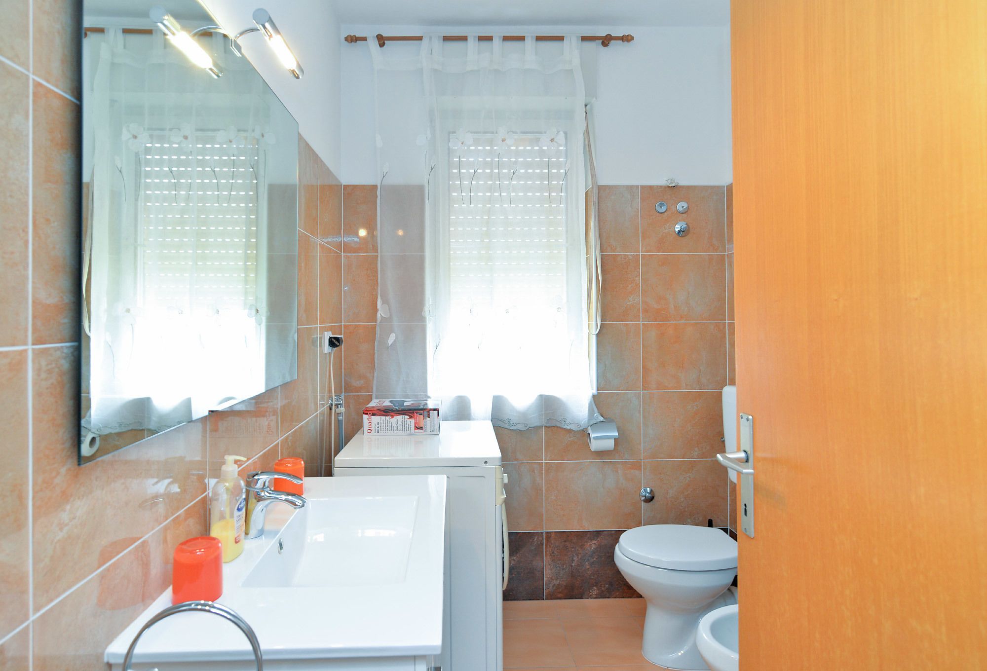 A bathroom with a sink, mirror, toilet, and shower.