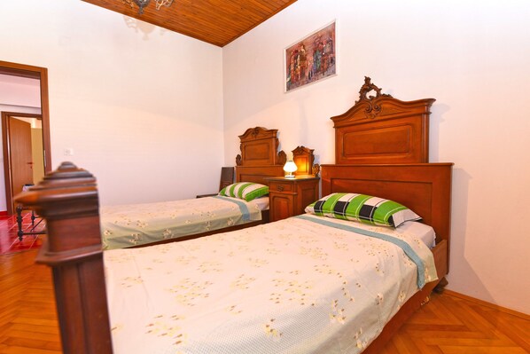 A room with two wooden beds, each with a nightstand and a lamp. - Apartment 1560 (Fazana)