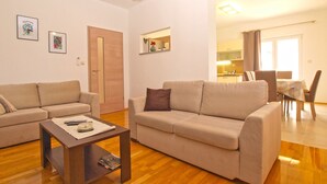 A living room with two sofas, a coffee table, and a dining area with a table and chairs. - Apartment 1573 (Fazana)