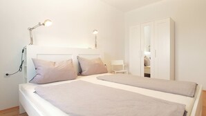 A bedroom with two beds, a wardrobe, and bedside lamps. - House 1581 (Pula)