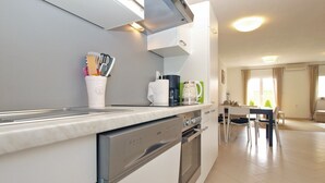 A modern kitchen with a built-in oven, a coffee maker, and a cup holder with utensils. - House 1581 (Pula)