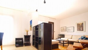 A living room with a sofa, coffee table, TV, and a bookshelf. - Apartment 1583 (Medulin)