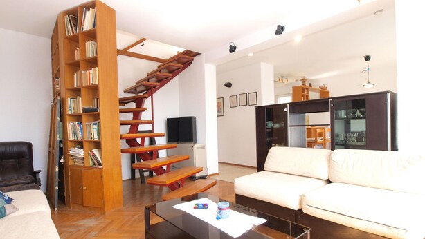 A living room with a wooden staircase, a white sofa, a glass coffee table, and a bookshelf. - Apartment 1583 (Medulin)