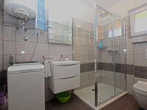 A modern bathroom with a glass-enclosed shower, a white sink, and a toilet. - Apartment 1592 (Pula)