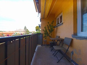 A balcony with a view of a sports field, a small table and chairs, and a potted plant. - Apartment 1592 (Pula)