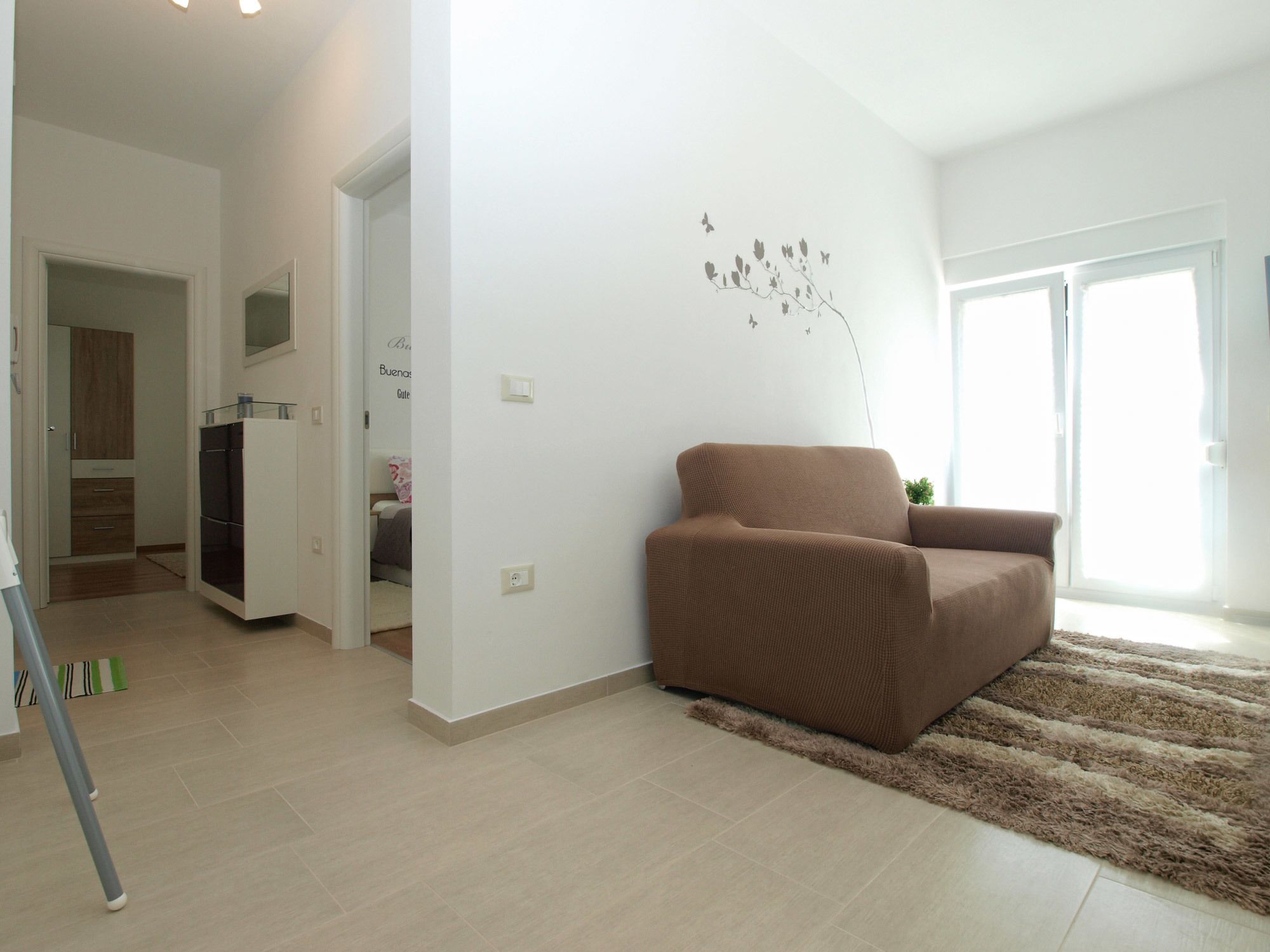 A modern living room with a brown sofa, a fluffy rug, and a wall decoration.