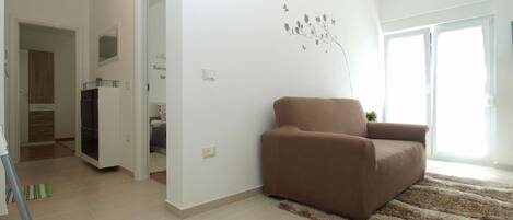 A modern living room with a brown sofa, a fluffy rug, and a wall decoration.