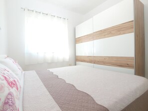 Un dormitorio con cama, ventana con cortinas y cabecero de madera.