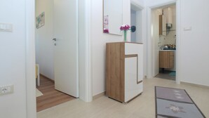 Un apartamento moderno con un armario de madera, un espejo y una zona de cocina.