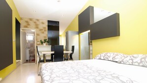A modern bedroom with a bed, a desk, and a chair. There is a mirror on the wall and a door leading to another room. - Apartment 1623 (Fazana)