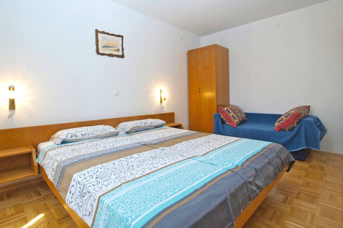 A bedroom with a wooden bed, a wardrobe, and two bedside lamps.