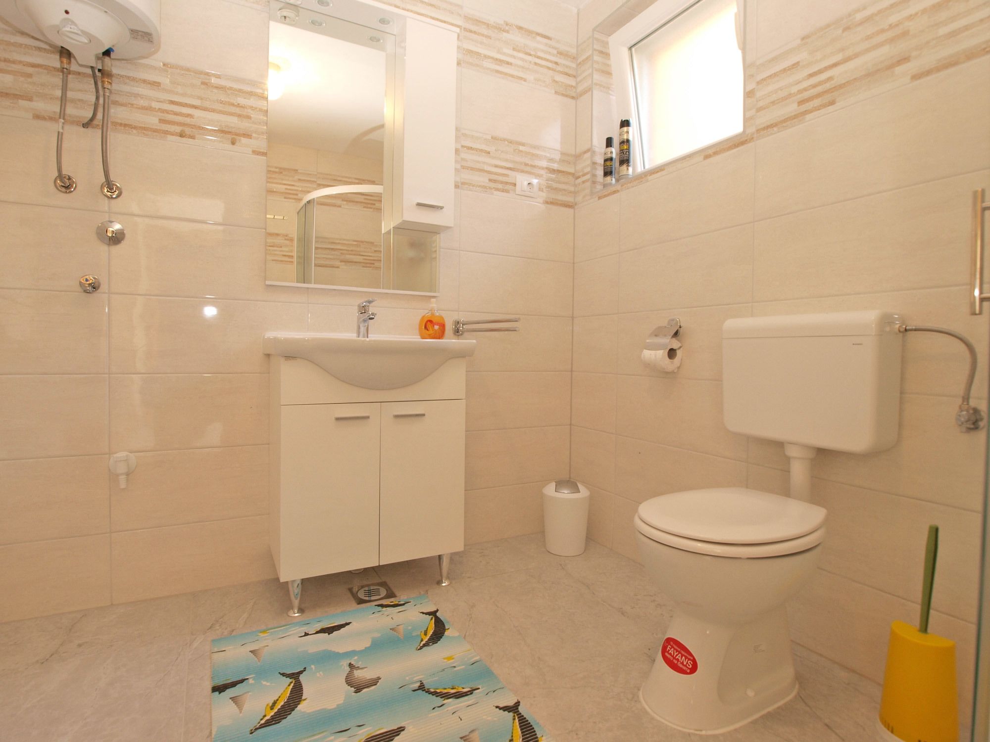 A bathroom with a toilet, sink, and shower.